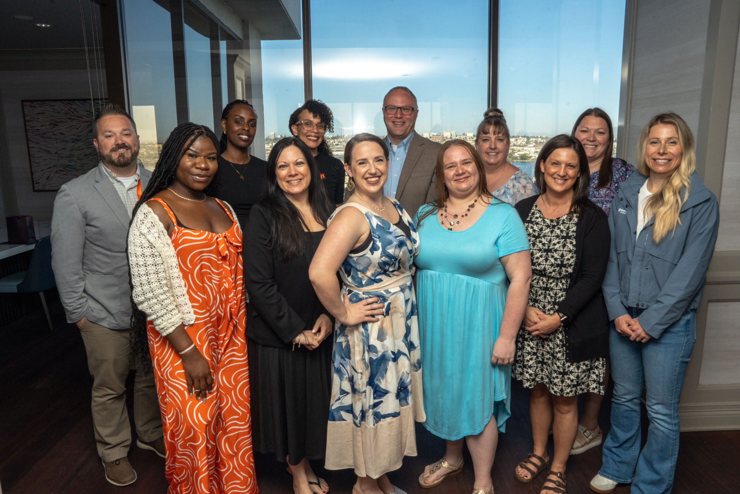 Twelve members of the Leadership Academy Class of 2025 posing for a group photo at their graduation ceremony.
